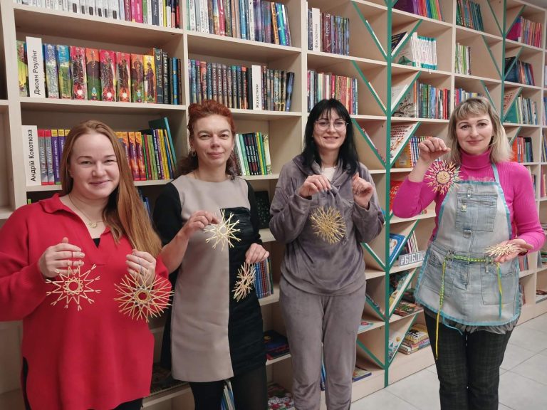 В бібліотеці на Пріорці відбулося справжнє чудо — майстер-клас із виготовлення солом'яних сніжинок. Учасниці цього творення отримали можливість створити неймовірно ніжні та мереживні сніжинки, які стали справжнім втіленням українських зимових традицій. Ці сніжинки, виготовлені з тонких соломинок, не тільки захоплюють своєю красою, але й мають глибоке сакральне значення. Здавна такі прикраси вважалися оберегами від злих духів і вішаються в домі від Різдва до Різдва. Участь у цьому процесі — це не просто творчість, це частина великої традиції, що зберігається через покоління. Солом'яні вироби — це частина багатовікової української традиції, що зберігається й до сьогодні. Виготовлення предметів із соломи було одним із основних ремесел селян. Адже солома була доступним і універсальним матеріалом. У минулі століття, коли не було таких технологій, як зараз, селяни створювали з соломи все необхідне для побуту. Від простих предметів для господарства до декору для свят і обрядів. Особливе місце серед таких виробів займали різдвяні прикраси. Солом'яні вироби мали глибоке сакральне значення і часто використовувалися як обереги від злих духів. Такі прикраси виготовляли в основному в період з Різдва до Різдва, і вони висіли в хатах, оберігаючи сім'ю від негараздів. Солом'яні сніжинки, зірки, вінки та інші декоративні елементи прикрашали оселі, наповнюючи їх не лише красою, а й духом свята та захисту. Традиція виготовлення таких виробів збереглася в багатьох українських селах. Зокрема, в центральних та західних регіонах, де особливо цінували цей вид народного мистецтва. З часом солом'яні прикраси стали не тільки елементами святкового декору, а й важливими атрибутами родинних обрядів. Існувала певна символіка, пов'язана з різними видами солом'яних виробів. Наприклад, солом'яні сніжинки і зірки вважалися символами зимового сонця, яке приносить тепло та світло в оселю. Важливим моментом було те, що ці вироби часто мали не тільки декоративну, але й магічну роль. Вони оберігали сім'ю, будинок і навіть худобу від нещасть, хвороб і негативних сил. Процес виготовлення солом'яних виробів потребував значних зусиль, оскільки солома не завжди була легкою для обробки. Плетіння, скручування та виготовлення фігур вимагають точності й майстерності. Кожен етап, від збору соломи до завершення виробу, був ретельно продуманим і потребував терпіння. Сьогодні солом'яні прикраси стали не лише частиною традиційного декору, а й сучасним елементом українського народного мистецтва. Вони знайомлять нові покоління з прадавніми звичаями та символікою. І хоча тепер для створення таких виробів використовують сучасні інструменти, дух давніх традицій і сьогодні відчувається в кожному солом'яному виробі. Прикраси несуть в собі енергетику захисту, тепла та родинного затишку. Майстриня пані Наталія Курінна подарувала учасницям події незабутній досвід та допомогла створити справжні витвори мистецтва. Після завершення майстер-класу панянки залишились з чудовими сніжинками. Вони точно не будуть спалювати їх, а з гордістю милуватимуться результатами своєї праці. Бібліотека на Пріорці чекає на нові зустрічі та майстер-класи, що наповнюють наші серця українським духом!